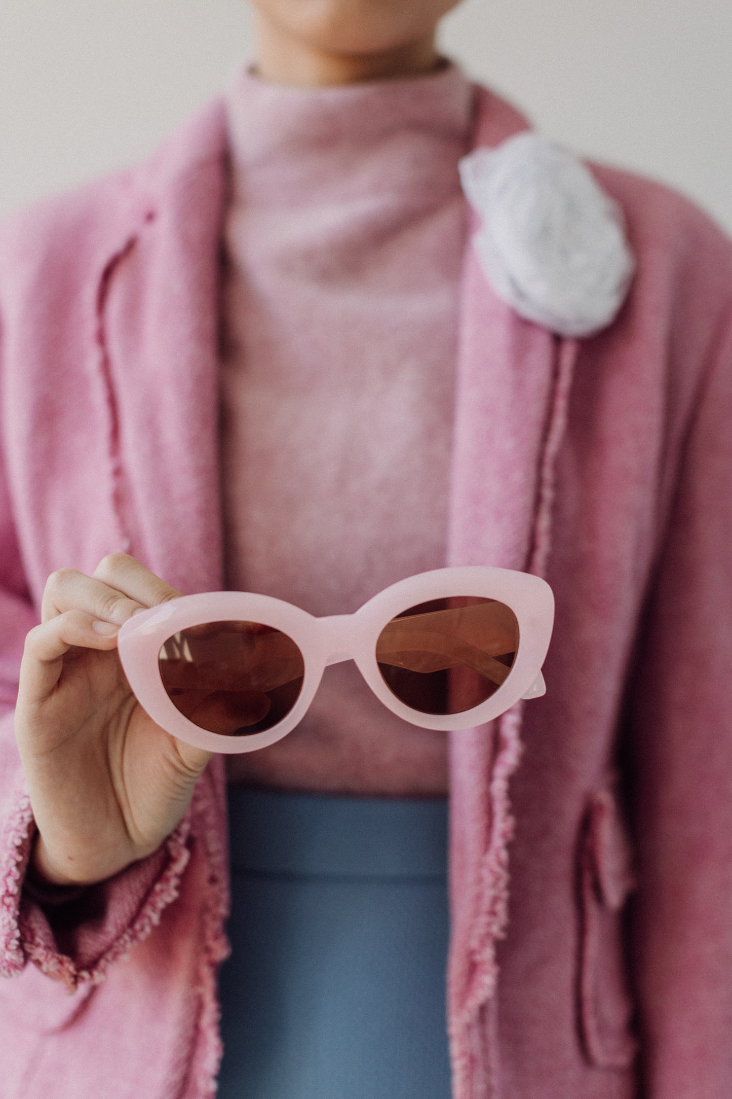 Woman Holding Pink Sunglasses